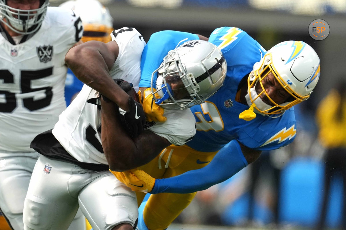 Sep 8, 2024; Inglewood, California, USA; Las Vegas Raiders running back Zamir White (left) is tackled by Los Angeles Chargers safety Derwin James Jr (3) in the second half at SoFi Stadium. Credit: Kirby Lee-Imagn Images