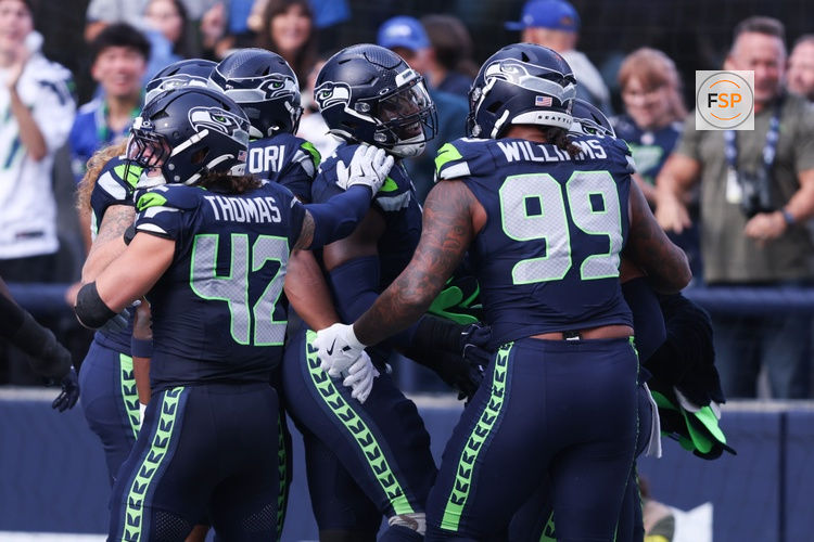Nov 9, 2025; Seattle, Washington, USA; Seattle Seahawks defensive end DeMarcus Lawrence (0) celebrates with Seattle Seahawks defensive end Leonard Williams (99) and Seattle Seahawks linebacker Drake Thomas (42) after recovering a fumble to score a touchdown during the second quarter against the Arizona Cardinals at Lumen Field. Credit: Kevin Ng-Imagn Images