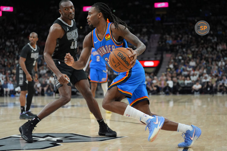 Mar 2, 2025; San Antonio, Texas, USA;  Oklahoma City Thunder guard Cason Wallace (22) dribbles past San Antonio Spurs center Bismack Biyombo (18) in the second half at Frost Bank Center. Credit: Daniel Dunn-Imagn Images