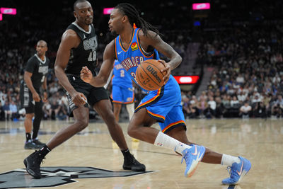 Mar 2, 2025; San Antonio, Texas, USA;  Oklahoma City Thunder guard Cason Wallace (22) dribbles past San Antonio Spurs center Bismack Biyombo (18) in the second half at Frost Bank Center. Mandatory Credit: Daniel Dunn-Imagn Images