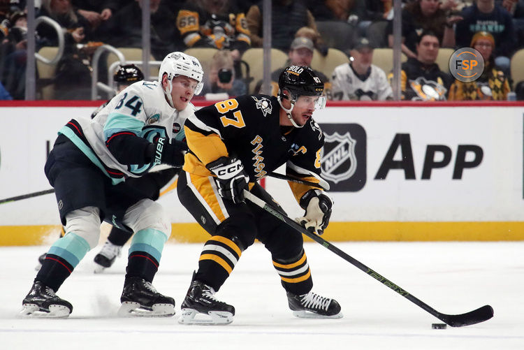 Jan 14, 2025; Pittsburgh, Pennsylvania, USA;  Pittsburgh Penguins center Sidney Crosby (87) skates with the puck as Seattle Kraken right wing Kaapo Kakko (84) chases during the first period at PPG Paints Arena. Credit: Charles LeClaire-Imagn Images