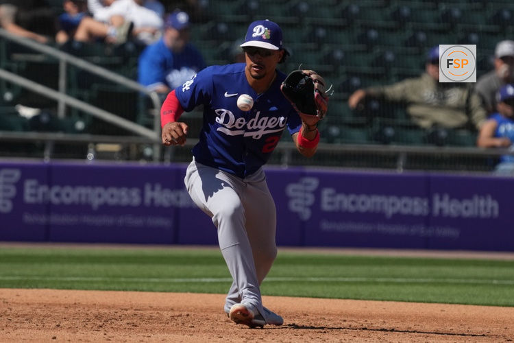 Mar 8, 2026; Mesa, Arizona, USA; Los Angeles Dodgers third baseman Santiago Espinal (21) makes the play against the Athletics in the third inning at Hohokam Stadium. Credit: Rick Scuteri-Imagn Images