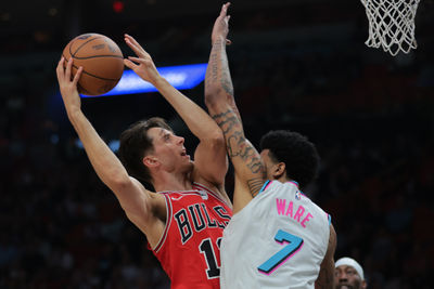 Mar 8, 2025; Miami, Florida, USA; Chicago Bulls forward Zach Collins (12) drives to the basket against Miami Heat center Kel'el Ware (7) during the first quarter at Kaseya Center. Mandatory Credit: Sam Navarro-Imagn Images