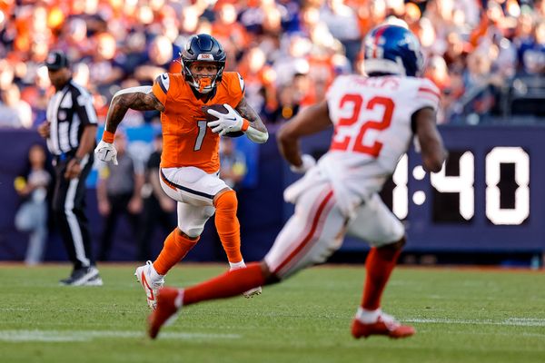 Oct 19, 2025; Denver, Colorado, USA; Denver Broncos tight end Evan Engram (1) runs the ball as New York Giants cornerback Dru Phillips (22) defends in the third quarter at Empower Field at Mile High. Mandatory Credit: Isaiah J. Downing-Imagn Images