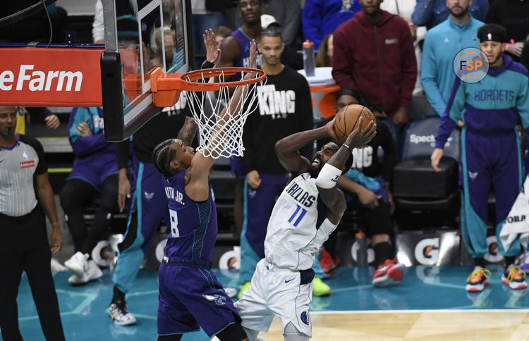 Jan 20, 2025; Charlotte, North Carolina, USA;  Dallas Mavericks guard Kyrie Irving (11) drives in as he is defended by Charlotte Hornets guard Nick Smith Jr. (8) during the second half at the Spectrum Center. Credit: Sam Sharpe-Imagn Images