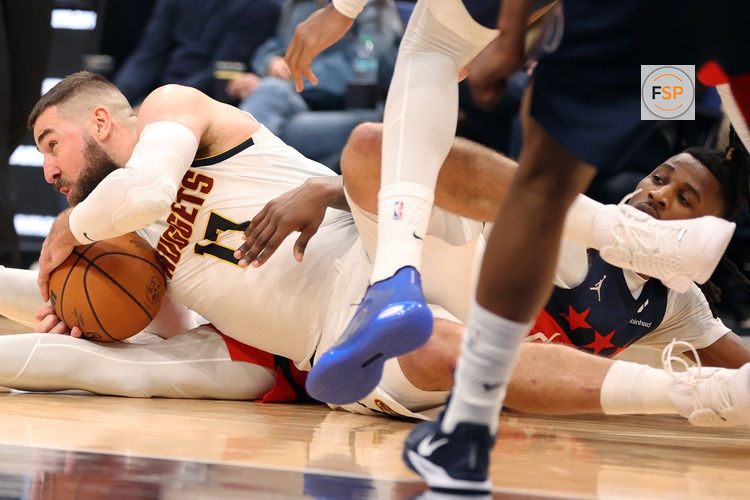 Jan 22, 2026; Washington, District of Columbia, USA; Denver Nuggets center Jonas Valanciunas (17) fights for the ball against Washington Wizards guard Jamir Watkins (5) during the second half at Capital One Arena. Credit: Daniel Kucin Jr.-Imagn Images