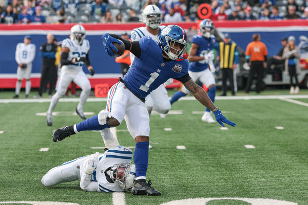 Dec 29, 2024; East Rutherford, New Jersey, USA; New York Giants wide receiver Malik Nabers (1) breaks a tackle by Indianapolis Colts safety Julian Blackmon (32) during a touchdown reception during the first half at MetLife Stadium. Mandatory Credit: Vincent Carchietta-Imagn Images