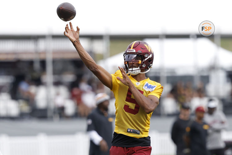 Jul 26, 2024; Ashburn, VA, USA; Washington Commanders quarterback Jayden Daniels (5) passes the ball on day three of training camp at Commanders Park. Mandatory Credit: Geoff Burke-USA TODAY Sports