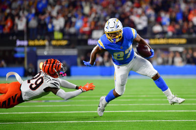 Nov 17, 2024; Inglewood, California, USA; Los Angeles Chargers running back J.K. Dobbins (27) runs the ball ahead of Cincinnati Bengals cornerback Cam Taylor-Britt (29) to score a touchdow during the second half at SoFi Stadium. Mandatory Credit: Gary A. Vasquez-Imagn Images