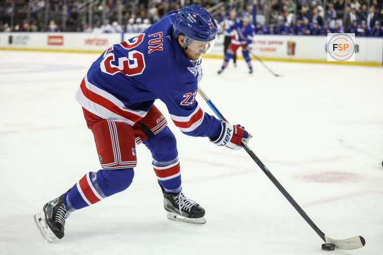 Nov 29, 2025; New York, New York, USA;  New York Rangers defenseman Adam Fox (23) controls the puck in the second period against the Tampa Bay Lightning at Madison Square Garden. Credit: Wendell Cruz-Imagn Images