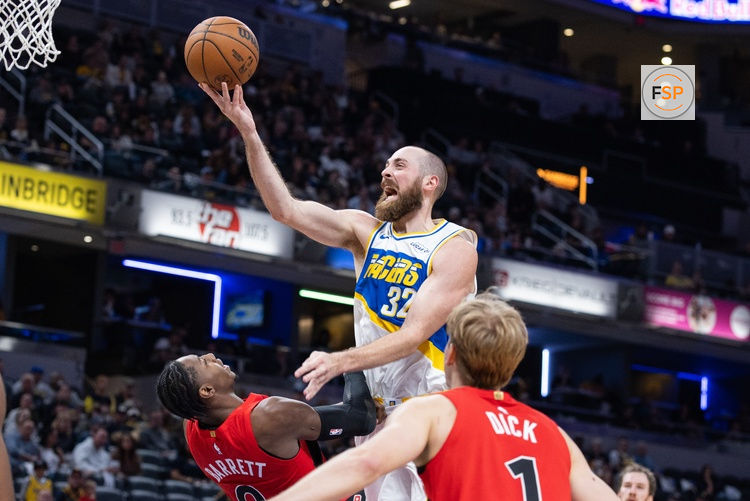 Nov 15, 2025; Indianapolis, Indiana, USA;  Indiana Pacers center Jay Huff (32) shoots the ball while Toronto Raptors forward/guard RJ Barrett (9) defends in the second half at Gainbridge Fieldhouse. Credit: Trevor Ruszkowski-Imagn Images
