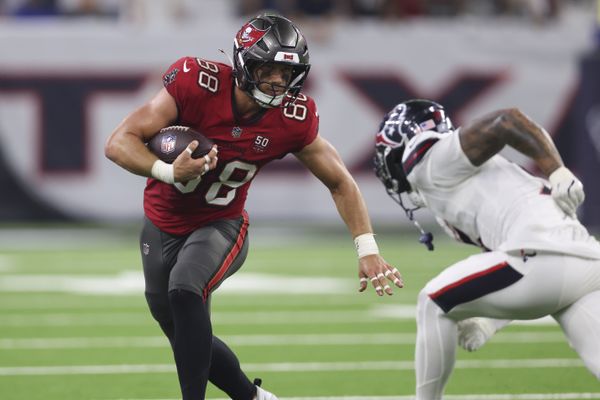 Sep 15, 2025; Houston, Texas, USA; Tampa Bay Buccaneers tight end Cade Otton (88) runs with the ball after a recpetion as Houston Texans safety Jalen Pitre (5) attempts to make a tackle during the fourth quarter at NRG Stadium. Mandatory Credit: Troy Taormina-Imagn Images