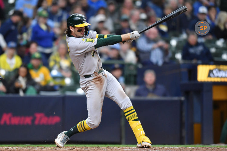 Apr 20, 2025; Milwaukee, Wisconsin, USA; Athletics shortstop Jacob Wilson (5) hits a single during the seventh inning against the Milwaukee Brewers at American Family Field. Credit: Patrick Gorski-Imagn Images