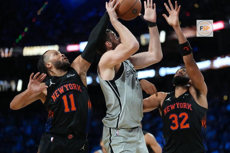 Dec 16, 2025; Las Vegas, Nevada, USA; New York Knicks guard Jalen Brunson (11), center Karl-Anthony Towns (32) attempt to block the shot of San Antonio Spurs center Luke Kornet (7) during the Emirates NBA Cup Final at T-Mobile Arena. Credit: Kirby Lee-Imagn Images