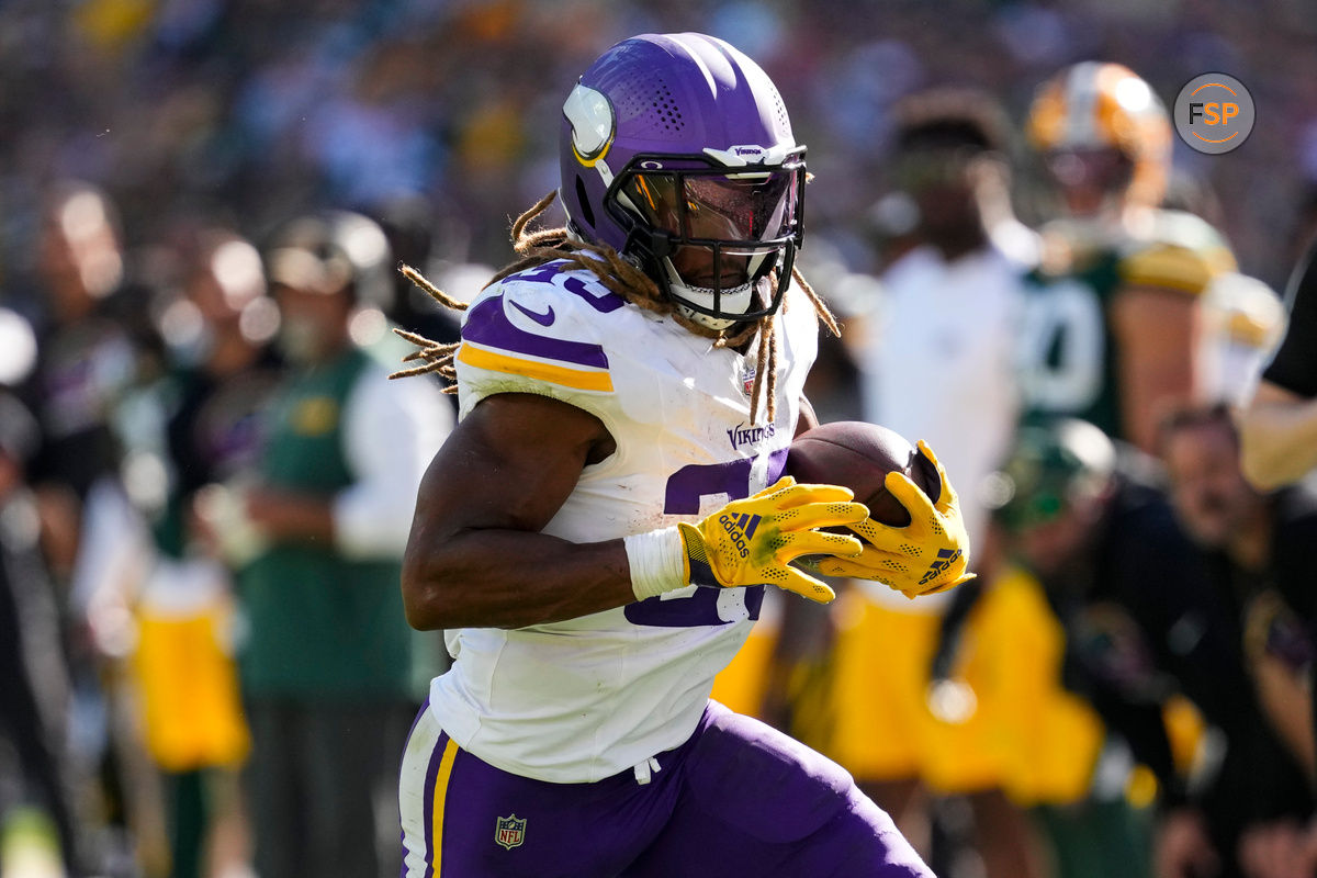 Sep 29, 2024; Green Bay, Wisconsin, USA;  Minnesota Vikings running back Aaron Jones (33) rushes with the football during the fourth quarter against the Green Bay Packers at Lambeau Field. Credit: Jeff Hanisch-Imagn Images