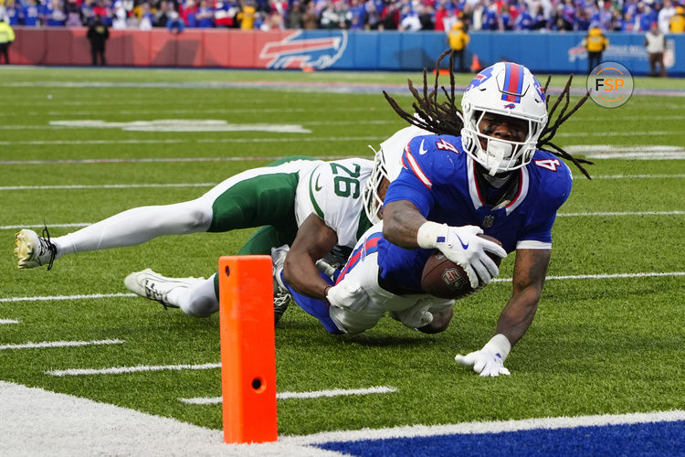 Dec 29, 2024; Orchard Park, New York, USA; Buffalo Bills running back James Cook (4) reaches for the end zone as he is tackled by New York Jets cornerback Brandin Echols (26) during the second half at Highmark Stadium. Credit: Gregory Fisher-Imagn Images