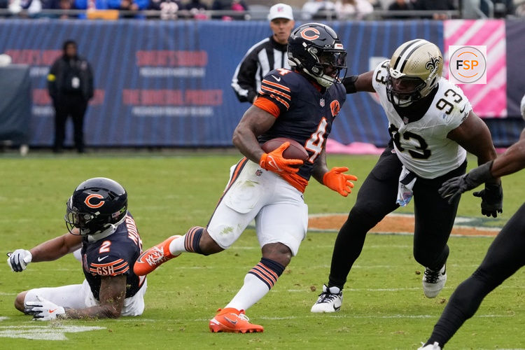 Oct 19, 2025; Chicago, Illinois, USA; Chicago Bears running back D'Andre Swift (4) runs with the ball against New Orleans Saints defensive tackle Nathan Shepherd (93) during the second half at Soldier Field. Credit: David Banks-Imagn Images