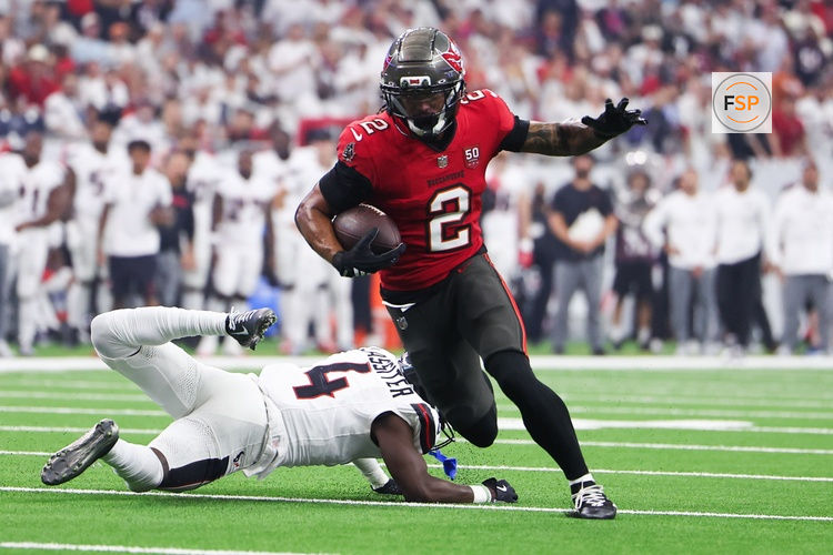 Sep 15, 2025; Houston, Texas, USA; Tampa Bay Buccaneers wide receiver Emeka Egbuka (2) runs for a touchdown as Houston Texans cornerback Kamari Lassiter (4) defends during the second quarter at NRG Stadium. Credit: Troy Taormina-Imagn Images