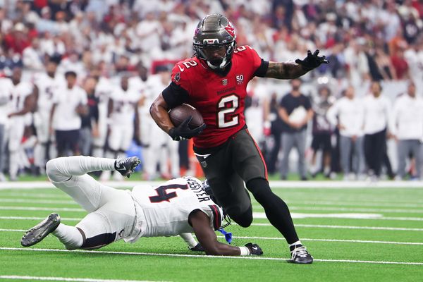 Sep 15, 2025; Houston, Texas, USA; Tampa Bay Buccaneers wide receiver Emeka Egbuka (2) runs for a touchdown as Houston Texans cornerback Kamari Lassiter (4) defends during the second quarter at NRG Stadium. Mandatory Credit: Troy Taormina-Imagn Images