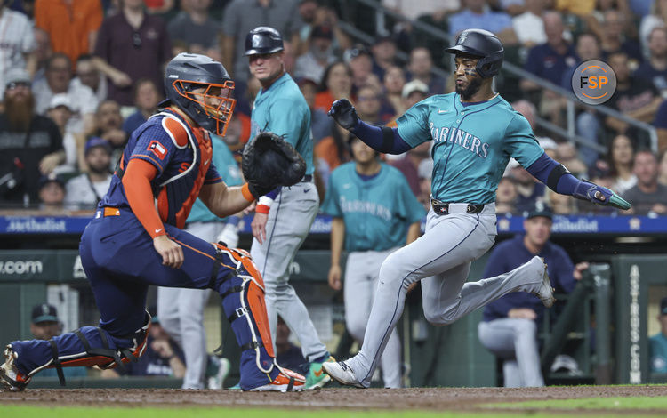 Sep 23, 2024; Houston, Texas, USA; Seattle Mariners right fielder Victor Robles (10) slides safely past Houston Astros catcher Yainer Diaz (21) to score a run during the third inning at Minute Maid Park. Credit: Troy Taormina-Imagn Images