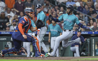 Sep 23, 2024; Houston, Texas, USA; Seattle Mariners right fielder Victor Robles (10) slides safely past Houston Astros catcher Yainer Diaz (21) to score a run during the third inning at Minute Maid Park. Mandatory Credit: Troy Taormina-Imagn Images