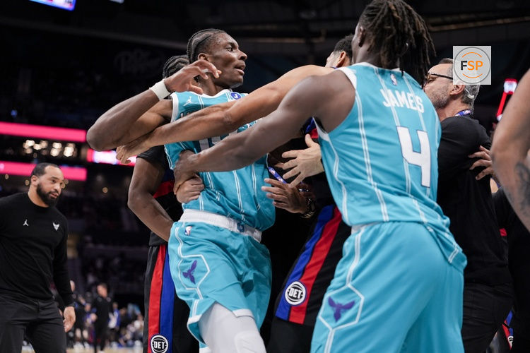 Feb 9, 2026; Charlotte, North Carolina, USA;  Charlotte Hornets forward Moussa Diabaté (14) is held back by guard Sion James (4) engaging with Detroit Pistons forward Tobias Harris (12) during the second half at Spectrum Center. Credit: Jim Dedmon-Imagn Images