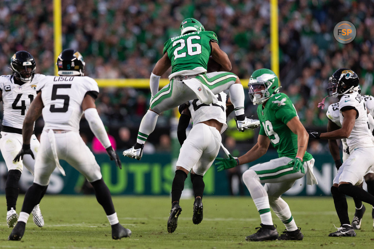 Nov 3, 2024; Philadelphia, Pennsylvania, USA; Philadelphia Eagles running back Saquon Barkley (26) leaps backwards over Jacksonville Jaguars cornerback Jarrian Jones (22) at Lincoln Financial Field. Credit: Bill Streicher-Imagn Images