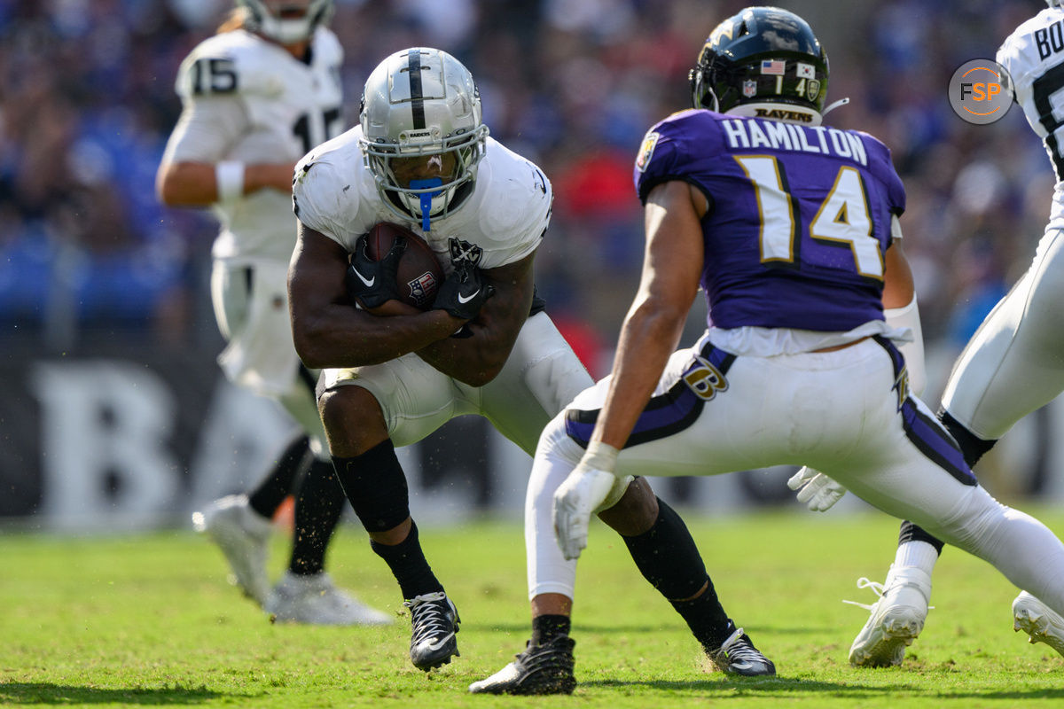 Sep 15, 2024; Baltimore, Maryland, USA; Las Vegas Raiders running back Zamir White (3) runs the ball as Baltimore Ravens safety Kyle Hamilton (14) defends during the second half at M&T Bank Stadium. Credit: Reggie Hildred-Imagn Images