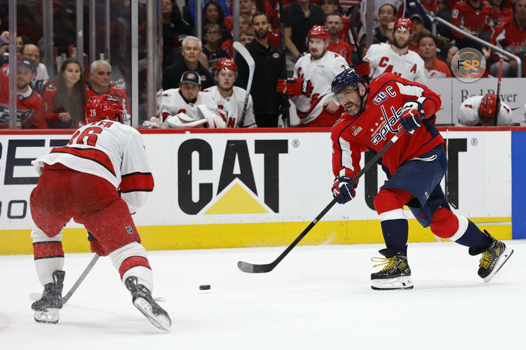 May 15, 2025; Washington, District of Columbia, USA; Washington Capitals left wing Alex Ovechkin (8) shoots the puck as Carolina Hurricanes defenseman Sean Walker (26) defends in the third period in game five of the second round of the 2025 Stanley Cup Playoffs at Capital One Arena. Credit: Geoff Burke-Imagn Images
