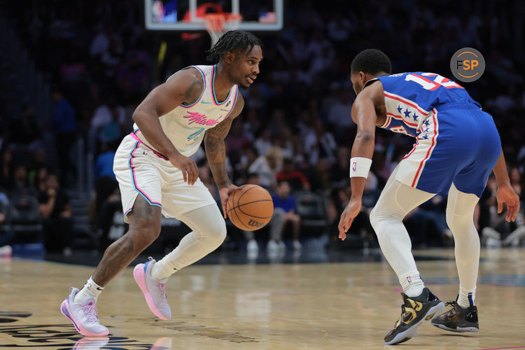 Apr 7, 2025; Miami, Florida, USA; Miami Heat guard Davion Mitchell (45) dribbles the basketball as Philadelphia 76ers guard Jared Butler (12) defends during the first quarter at Kaseya Center. Credit: Sam Navarro-Imagn Images