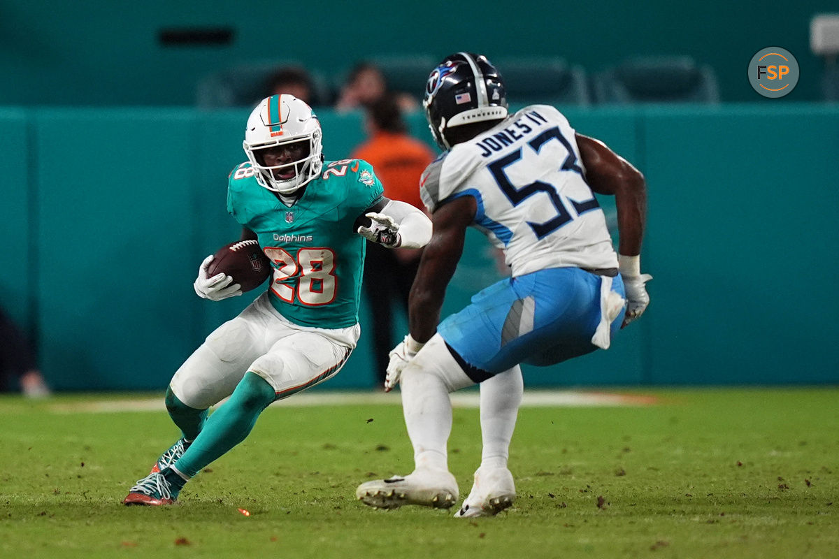 Sep 30, 2024; Miami Gardens, Florida, USA; Miami Dolphins running back De'Von Achane (28) runs the ball against Tennessee Titans linebacker Ernest Jones IV (53) during the second half at Hard Rock Stadium. Credit: Jasen Vinlove-Imagn Images