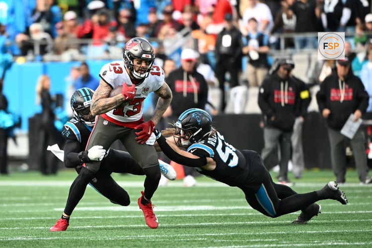 Dec 21, 2025; Charlotte, North Carolina, USA;  Tampa Bay Buccaneers wide receiver Mike Evans (13) with the ball as Carolina Panthers safety Nick Scott (21) and linebacker Christian Rozeboom (56) defend in the fourth quarter at Bank of America Stadium. Credit: Bob Donnan-Imagn Images