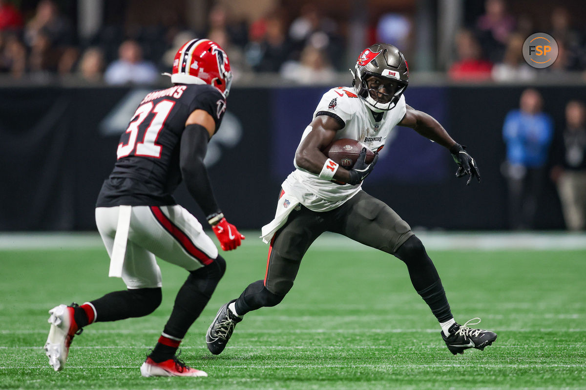 Oct 3, 2024; Atlanta, Georgia, USA; Tampa Bay Buccaneers wide receiver Chris Godwin (14) is pursued by Atlanta Falcons safety Justin Simmons (31) in the first quarter at Mercedes-Benz Stadium. Credit: Brett Davis-Imagn Images