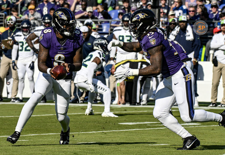 BALTIMORE, MD - NOVEMBER 05:  Baltimore Ravens quarterback Lamar Jackson (8) hands the ball off to running back Gus Edwards (35) during the Seattle Seahawks game versus the Baltimore Ravens on November 5, 2023 at M&T Bank Stadium in Baltimore, MD.  (Photo by Mark Goldman/Icon Sportswire)