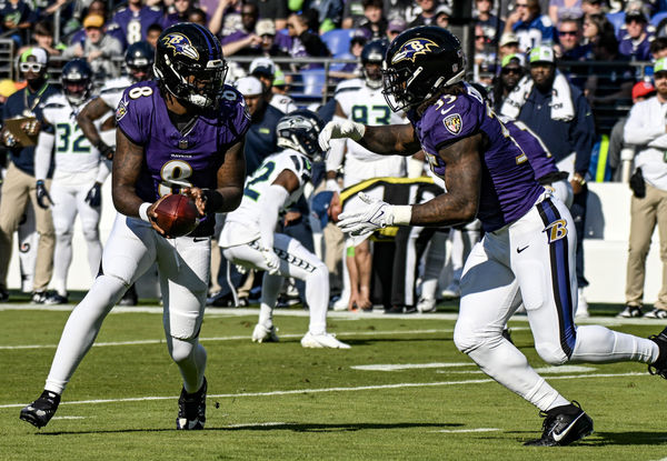 BALTIMORE, MD - NOVEMBER 05:  Baltimore Ravens quarterback Lamar Jackson (8) hands the ball off to running back Gus Edwards (35) during the Seattle Seahawks game versus the Baltimore Ravens on November 5, 2023 at M&T Bank Stadium in Baltimore, MD.  (Photo by Mark Goldman/Icon Sportswire)