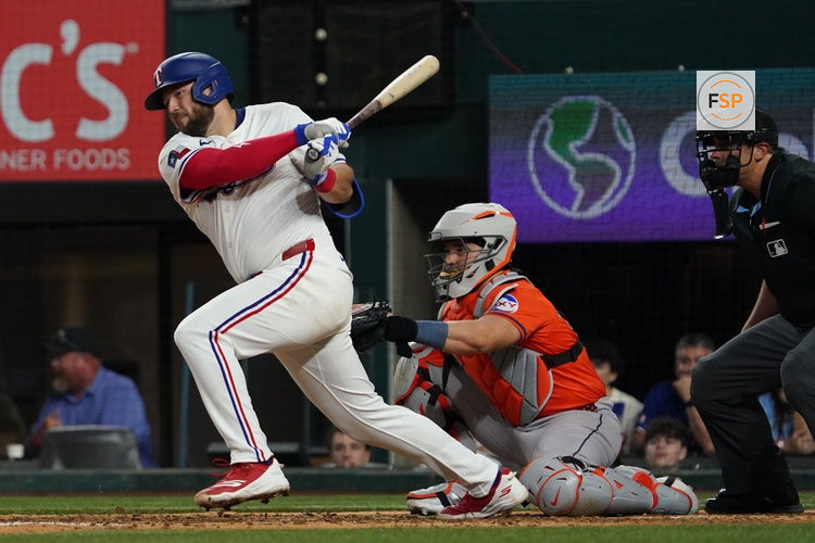 May 15, 2025; Arlington, Texas, USA; Texas Rangers first baseman Jake Burger (21) hits a single during the eighth inning against the Houston Astros at Globe Life Field. Credit: Raymond Carlin III-Imagn Images