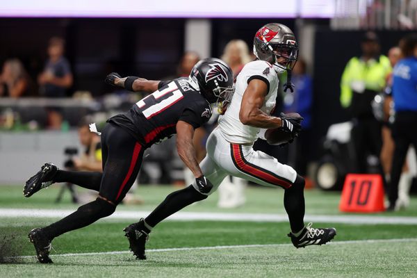 Sep 7, 2025; Atlanta, Georgia, USA; Tampa Bay Buccaneers wide receiver Emeka Egbuka (2) runs with the ball for a touchdown against Atlanta Falcons cornerback Mike Hughes (21) during the second quarter at Mercedes-Benz Stadium. Mandatory Credit: Brett Davis-Imagn Images