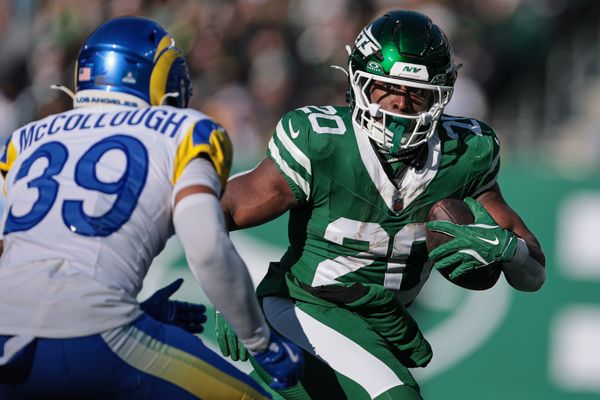 Dec 22, 2024; East Rutherford, New Jersey, USA; New York Jets running back Breece Hall (20) carries the ball asLos Angeles Rams safety Jaylen McCollough (39) pursues during the first half at MetLife Stadium. Mandatory Credit: Vincent Carchietta-Imagn Images