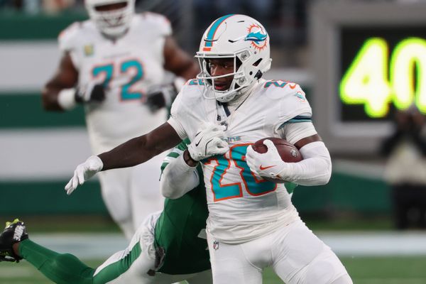 Jan 5, 2025; East Rutherford, New Jersey, USA; Miami Dolphins running back De'Von Achane (28) runs with the ball while New York Jets cornerback D.J. Reed (4) attempts to tackle him during the first quarter at MetLife Stadium. Mandatory Credit: Ed Mulholland-Imagn Images