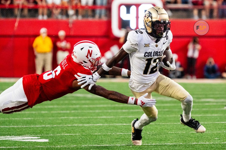 Sep 7, 2024; Lincoln, Nebraska, USA; Colorado Buffaloes wide receiver Travis Hunter (12) stiff arms Nebraska Cornhuskers defensive back Tommi Hill (6) during the second quarter at Memorial Stadium. Credit: Dylan Widger-Imagn Images