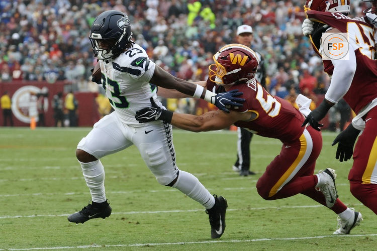 Sep 27, 2026; Landover, Maryland, USA; Seattle Seahawks running back Emanuel Wilson (23) carries the ball as Washington Commanders linebacker Leo Chenal (54) chases at Northwest Stadium. Credit: Geoff Burke-Imagn Images
