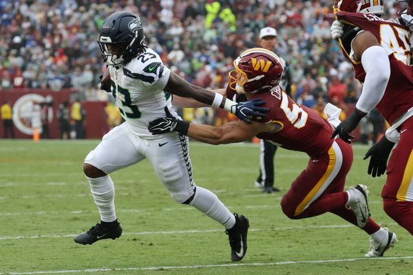 Sep 27, 2026; Landover, Maryland, USA; Seattle Seahawks running back Emanuel Wilson (23) carries the ball as Washington Commanders linebacker Leo Chenal (54) chases at Northwest Stadium. Mandatory Credit: Geoff Burke-Imagn Images