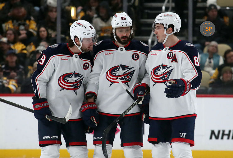 Jan 7, 2025; Pittsburgh, Pennsylvania, USA; Columbus Blue Jackets center Adam Fantilli (19) and right wing Kirill Marchenko (86) and defenseman Zach Werenski (8) talk before the start of the overtime period against the Pittsburgh Penguins at PPG Paints Arena. Credit: Charles LeClaire-Imagn Images