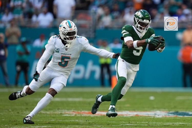Dec 8, 2024; Miami Gardens, Florida, USA; New York Jets wide receiver Garrett Wilson (5) runs with the ball away from Miami Dolphins cornerback Jalen Ramsey (5) during the first half at Hard Rock Stadium. Credit: Jasen Vinlove-Imagn Images