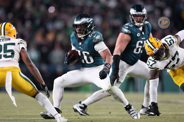 Jan 12, 2025; Philadelphia, Pennsylvania, USA; Philadelphia Eagles running back Saquon Barkley (26) rushes the ball against Green Bay Packers cornerback Keisean Nixon (25) in the fourth quarter in an NFC wild card game at Lincoln Financial Field. Credit: Bill Streicher-Imagn Images