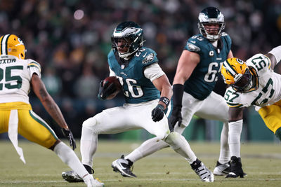 Jan 12, 2025; Philadelphia, Pennsylvania, USA; Philadelphia Eagles running back Saquon Barkley (26) rushes the ball against Green Bay Packers cornerback Keisean Nixon (25) in the fourth quarter in an NFC wild card game at Lincoln Financial Field. Mandatory Credit: Bill Streicher-Imagn Images