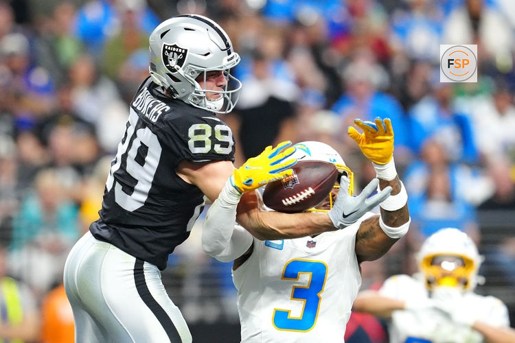 Jan 5, 2025; Paradise, Nevada, USA; Las Vegas Raiders tight end Brock Bowers (89) and Los Angeles Chargers safety Derwin James Jr. (3) reach for a pass during the fourth quarter at Allegiant Stadium. Credit: Stephen R. Sylvanie-Imagn Images