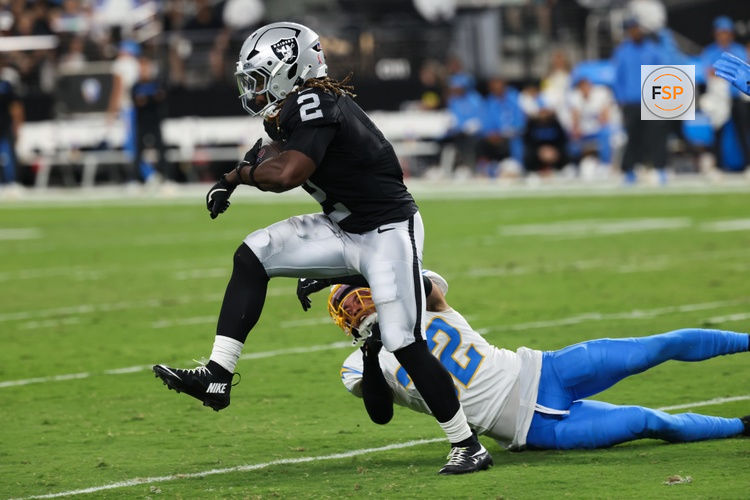 Sep 15, 2025; Paradise, Nevada, USA;  Las Vegas Raiders running back Ashton Jeanty (2) evades a tackle from Los Angeles Chargers safety Alohi Gilman (32) during the first quarter at Allegiant Stadium. Credit: Kiyoshi Mio-Imagn Images
