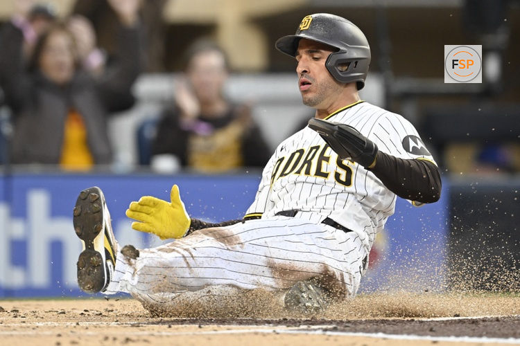 Apr 27, 2026; San Diego, California, USA; San Diego Padres right fielder Ramon Laureano (5) slides as he scores during the first inning against the Chicago Cubs at Petco Park. Credit: Denis Poroy-Imagn Images