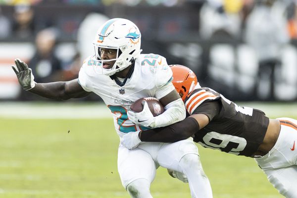 Dec 29, 2024; Cleveland, Ohio, USA; Miami Dolphins running back De'Von Achane (28) runs the ball as Cleveland Browns cornerback Cameron Mitchell (29) tackles him during the first quarter at Huntington Bank Field. Mandatory Credit: Scott Galvin-Imagn Images